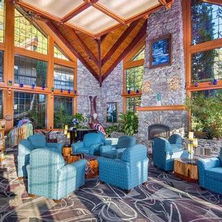 Best Western Plus Yosemite Gateway Inn | Oakhurst, California | Lobby area with blue armchairs and stone fireplace