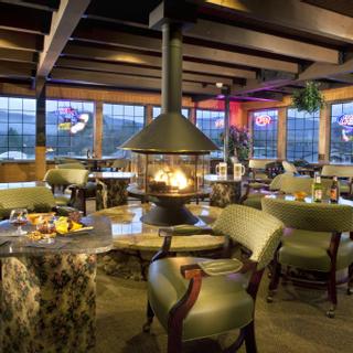 Best Western Plus Yosemite Gateway Inn | Oakhurst, California | Restaurant seating area with fireplace in center